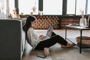 Girl sitting on the floor on her laptop.