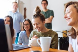 Group of people watching something on a laptop.